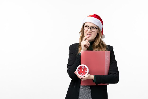 Vooraanzicht jonge vrouwelijke bedrijf klok en bestanden op witte muur college boek lessen