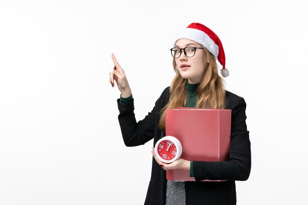 Vooraanzicht jonge vrouwelijke bedrijf klok en bestanden op witte muur lessen college boek