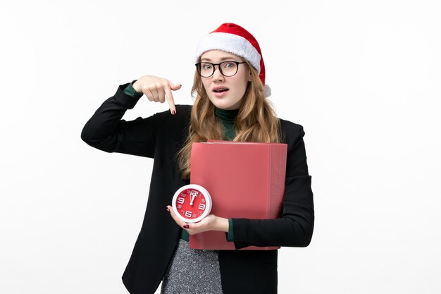 Vooraanzicht jonge vrouwelijke bedrijf klok en bestanden op witte vloer college boek les