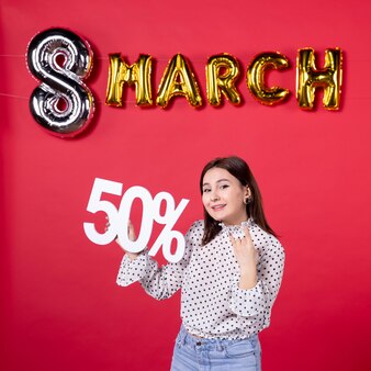 Vooraanzicht jonge vrouwelijke bedrijf schrijven op rode achtergrond winkelen gelijkheid aanhankelijk winkelcentrum vakantie vrouw geld