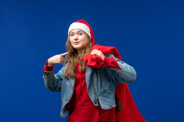 Vooraanzicht jonge vrouwelijke draagtas vol cadeautjes op blauwe bureau kleur emoties kerst