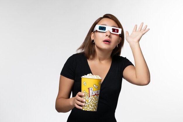 Vooraanzicht jonge vrouwelijke popcorn in d zonnebril kijken naar film op wit oppervlak