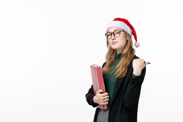 Vooraanzicht jonge vrouwelijke student met bestanden op een witte muur boek school college