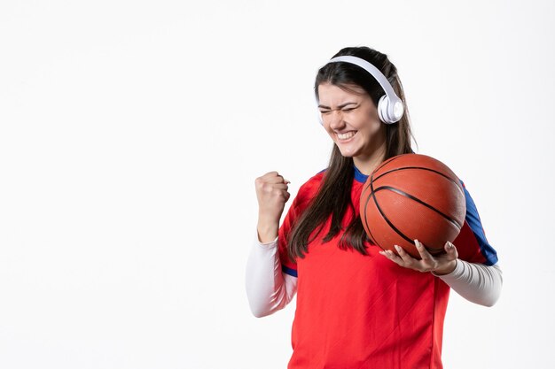 Vooraanzicht juichend jong wijfje in sportkleren met basketbal