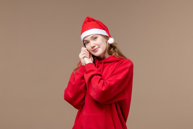 Vooraanzicht kerst meisje met lachend gezicht op bruine achtergrond vakantie kerst emotie