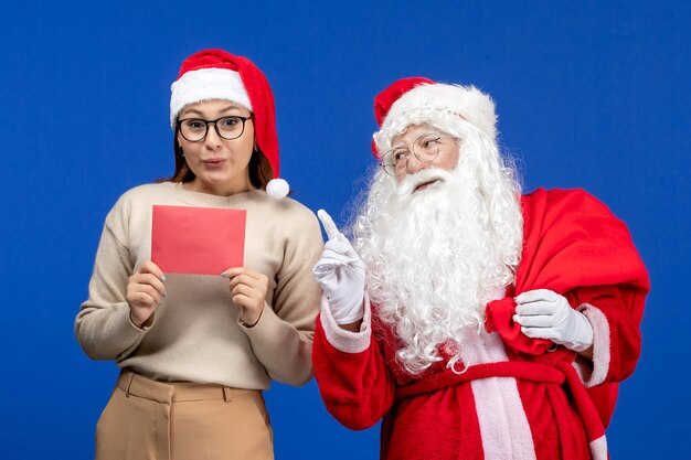 Vooraanzicht kerstman en jonge vrouw met letter op een blauwe vakantiegeest emotie kerstsneeuwkleur