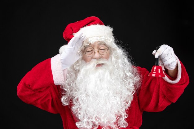 Vooraanzicht kerstman in klassiek rood pak met bel