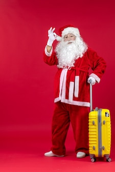 Vooraanzicht kerstman met gele tas die zich voorbereidt op reis