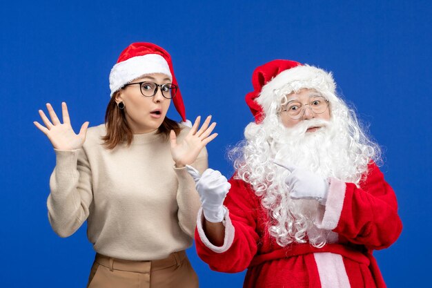 Vooraanzicht Kerstman met jonge vrouw staande op blauwe kleur sneeuw Kerstmis Nieuwjaar emoties