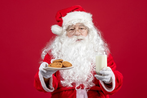 Vooraanzicht kerstman met koekjes en glas melk
