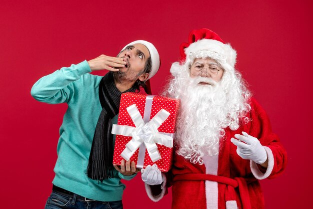 Vooraanzicht kerstman met man met vakantie aanwezig op rode cadeau-emotie kerstmis nieuwjaar rood