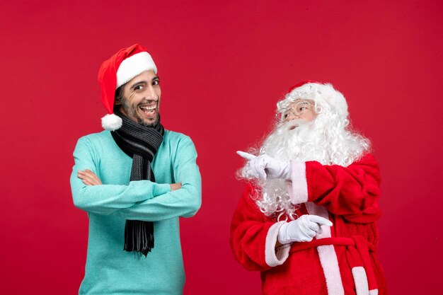Vooraanzicht kerstman met man staat gewoon op rode kerstvakantie aanwezig emotie stemming