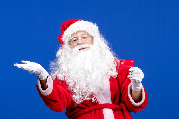 Vooraanzicht kerstman met rode bankkaart op de blauwe nieuwjaarskleur vakantie kerstcadeau