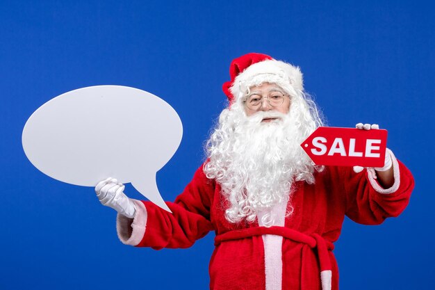 Vooraanzicht kerstman met verkoop en groot wit bord op blauwe kleur sneeuwvakantie nieuwjaar kerstmis