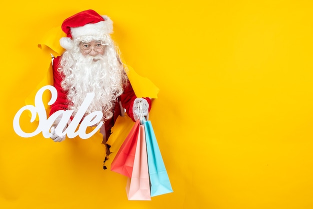 Gratis foto vooraanzicht kerstman met verkoop schrijven en cadeautjes