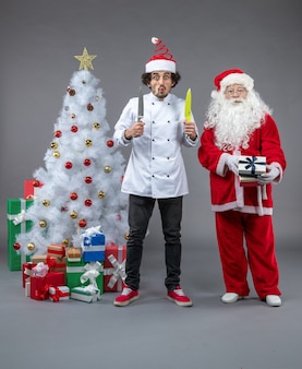 Vooraanzicht kerstman rond kerstcadeautjes met mannelijke kok