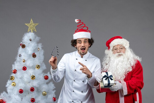 Vooraanzicht kerstman rond vakantieboom met mannelijke kok