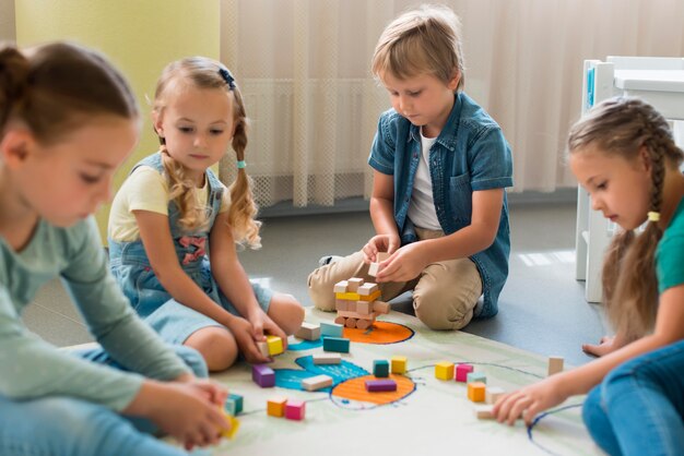 Vooraanzicht kinderen spelen samen in de kleuterschool