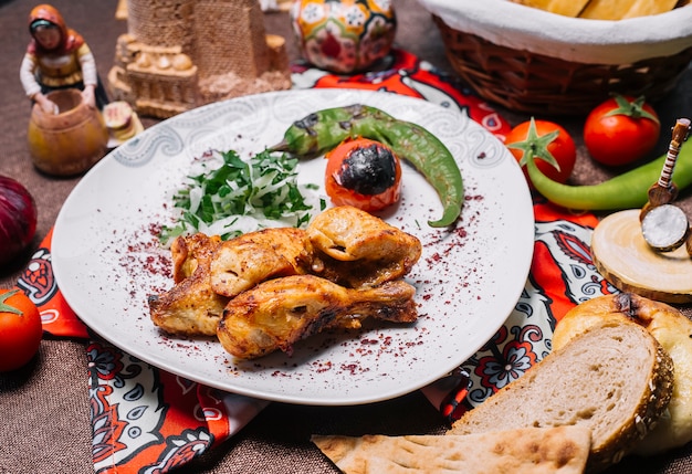 Vooraanzicht kip kebab met tomaat en hete peper op de grill met uien en kruiden