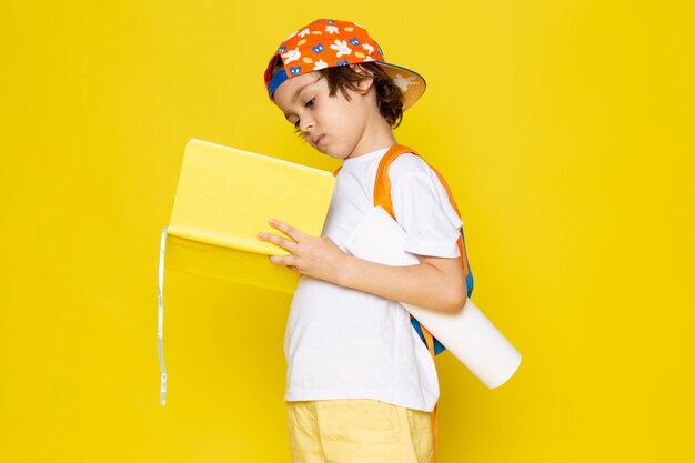 vooraanzicht klein kind in wit t-shirt schrift lezen op gele verdieping