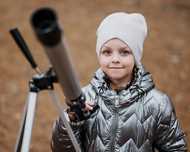 Gratis foto vooraanzicht klein kind met behulp van een telescoop