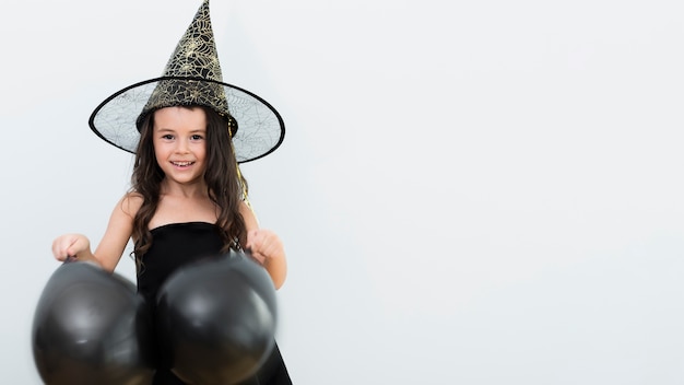 Vooraanzicht klein meisje in heks kostuum voor halloween