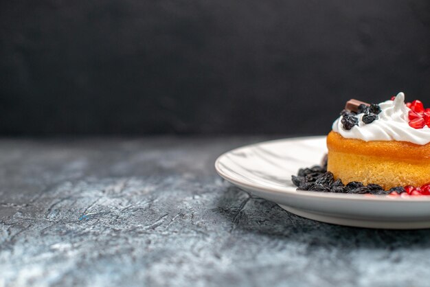 Vooraanzicht kleine heerlijke cake met chocolade en rozijnen op licht-donkere achtergrond