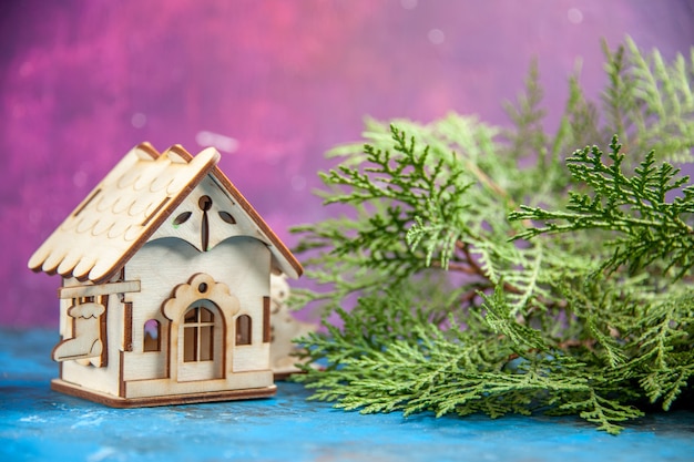 Gratis foto vooraanzicht kleine houten huis ceder takken op blauwe tafel