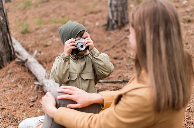 Gratis foto vooraanzicht kleine jongen die een foto van zijn moeder