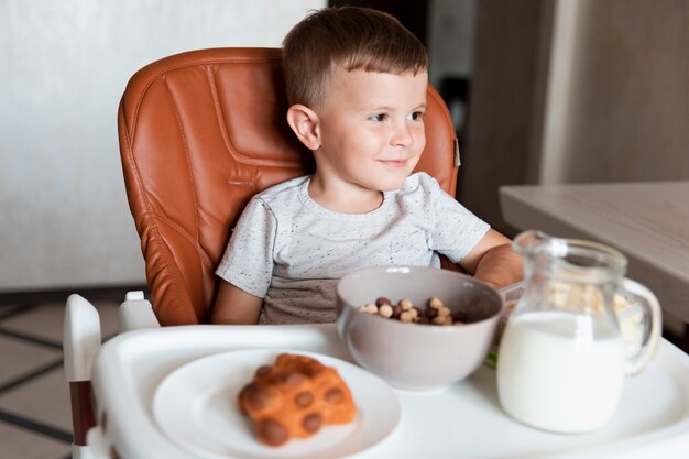 Vooraanzicht kleine jongen met assortiment snacks