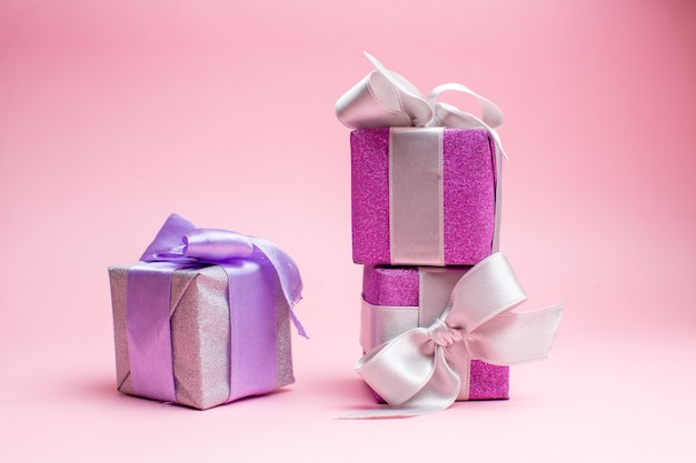 Vooraanzicht kleine kerstcadeautjes op roze kerstcadeau foto nieuwjaar vakantie kleur