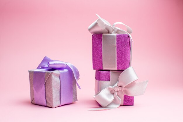 Vooraanzicht kleine kerstcadeautjes op roze kerstcadeau foto nieuwjaar vakantie kleur