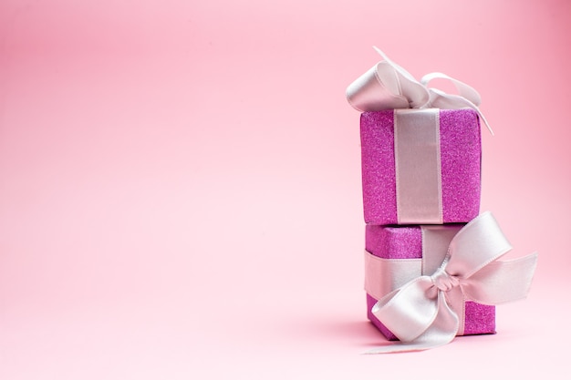 Vooraanzicht kleine kerstcadeautjes op roze kerstkleur cadeau foto nieuwjaar vakantie vrije ruimte