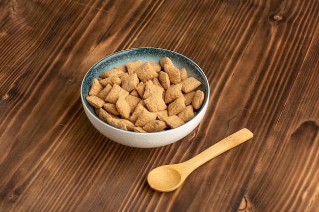 Vooraanzicht kleine kussen koekjes zoete koekjes op bruin bureau