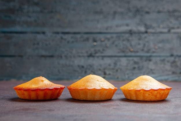 Vooraanzicht kleine lekkere taarten op donkere achtergrond taart biscuit taart zoete koekjes suiker thee