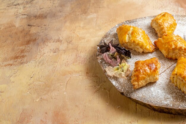 Vooraanzicht kleine zoete gebakjes voor thee op de lichte tafel zoete taart gebak cake