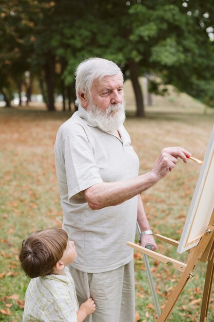 Vooraanzicht kleinzoon met opa schilderij