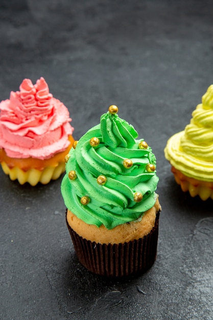 Gratis foto vooraanzicht kleurrijke cupcakes op dark