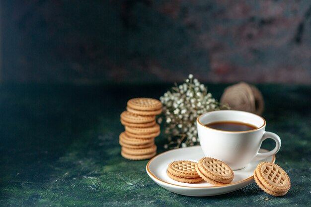 vooraanzicht kopje thee met kleine zoete koekjes in witte plaat op donkere achtergrond brood kleur ceremonie ontbijt ochtend drankje suiker foto