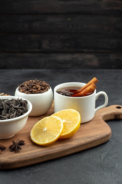 Vooraanzicht kopje thee met zwarte thee en schijfjes citroen op een donkere achtergrond ochtendkoffie kleur maaltijd tafel ontbijt ei familie