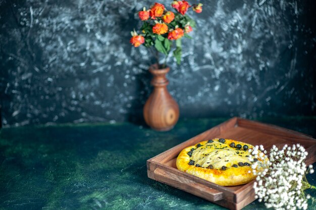 Vooraanzicht lekker brood op houten serveerplank bloemen in vaas op tafel vrije ruimte