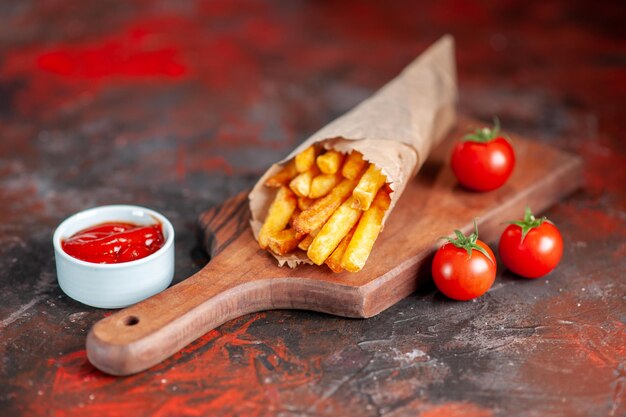 Vooraanzicht lekkere frietjes met rode tomaten en ketchup op donkere achtergrond schotel fastfood sandwich toast snack diner