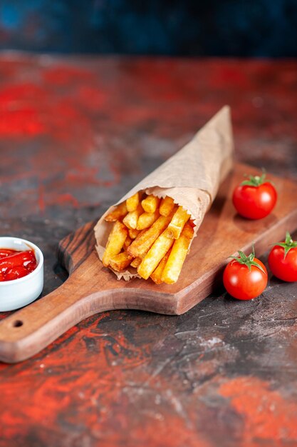 Vooraanzicht lekkere frietjes met rode tomaten en ketchup op donkere achtergrond schotel fastfood toast snack diner