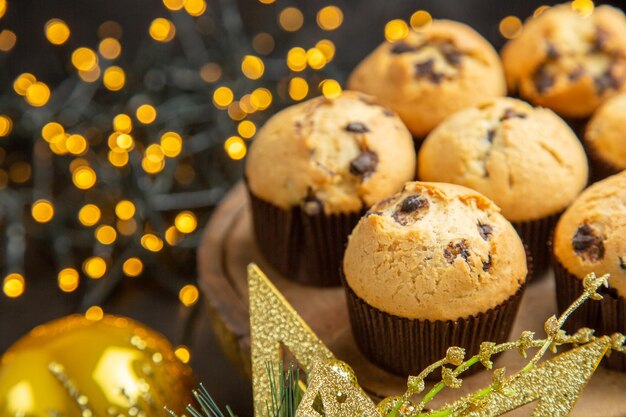 Vooraanzicht lekkere fruitige taarten rond kerstboomspeelgoed op donkere achtergrond