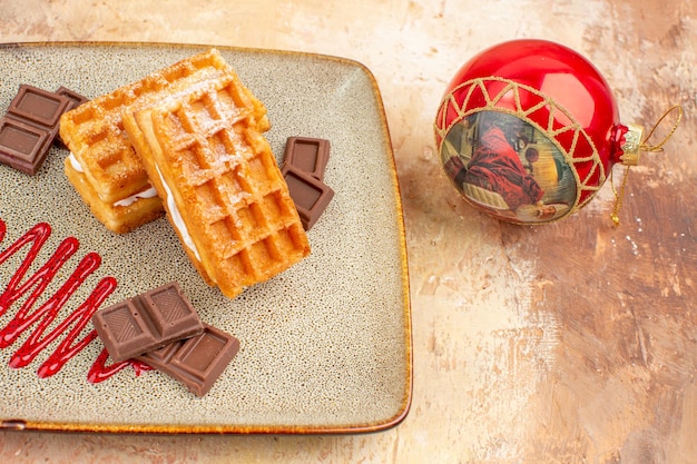 Vooraanzicht lekkere wafelcakes met chocoladerepen op de bruine achtergrond