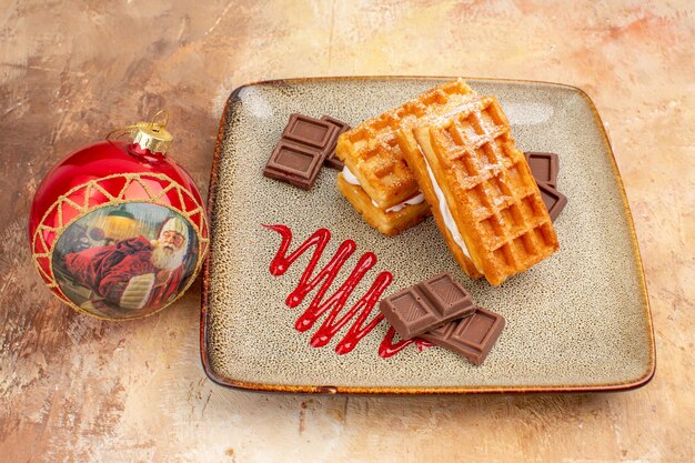 Vooraanzicht lekkere wafelcakes met chocoladerepen op de bruine achtergrond