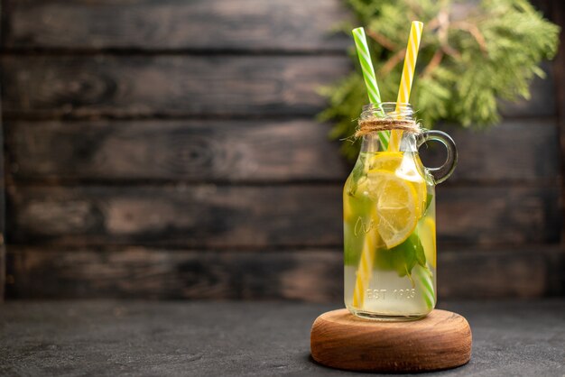 Vooraanzicht limonade op smaak gebracht door mint gele en groene pipetten op houten bord potplanten op het oppervlak
