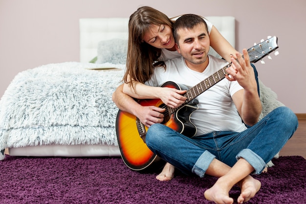 Vooraanzicht man en vrouw gitaar spelen