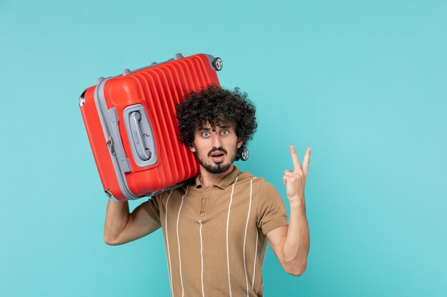 Vooraanzicht man in vakantie met zijn grote tas op blauw