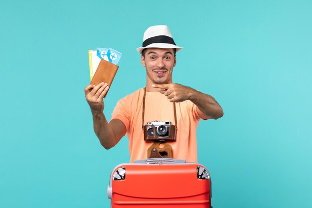 Vooraanzicht man in vakantie met zijn kaartjes op blauw